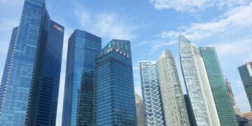 Singapore's Marina Bay financial district skyline with DBS and UOB bank towers, illustrating a story about wealthy Chinese individuals relocating wealth to Singapore
