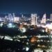 Elevated night view of the Pattaya, Thailand skyline, showing residential and commercial towers along the coast