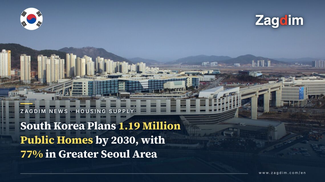 Aerial view of the Government Complex Sejong's long white terraced building with apartment towers and hills behind it