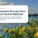 Calm sea with flowering bush and distant jetty, illustrating What Insurance Do Long-Term Foreigners Need in Malaysia?