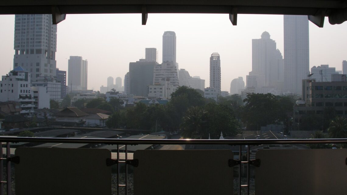 Central Bangkok skyline of condominium and office towers seen from a covered balcony
