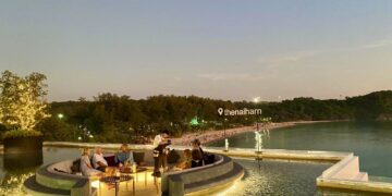 Poolside lounge deck at a Phuket resort overlooking the beach at dusk