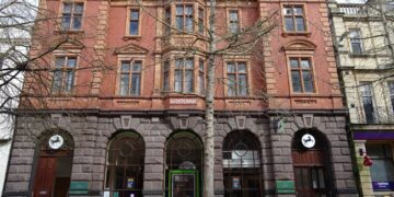Red-brick facade of a Lloyds Bank branch in Gloucester, UK, with the LLOYDS BANK signage clearly visible