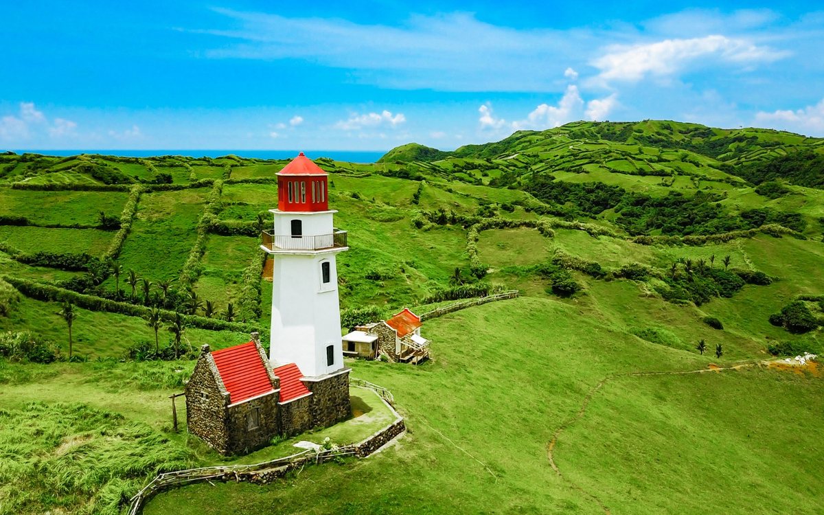 Tayid lighthouse on green hills in Batanes, showing the quieter side of retirement living in the Philippines under the SRRV