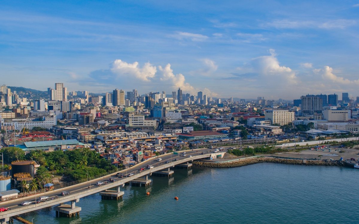 Cebu City skyline and bridge over the channel, showing city life for SRRV retirees in the Philippines