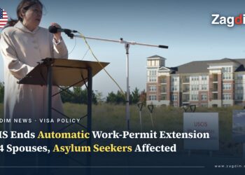 A DHS official speaks at the 2017 USCIS headquarters groundbreaking ceremony in Camp Springs, Maryland, with a 'USCIS HEADQUARTERS Groundbreaking' sign visible, illustrating a story on DHS/USCIS ending automatic work-permit extensions