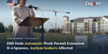 A DHS official speaks at the 2017 USCIS headquarters groundbreaking ceremony in Camp Springs, Maryland, with a 'USCIS HEADQUARTERS Groundbreaking' sign visible, illustrating a story on DHS/USCIS ending automatic work-permit extensions