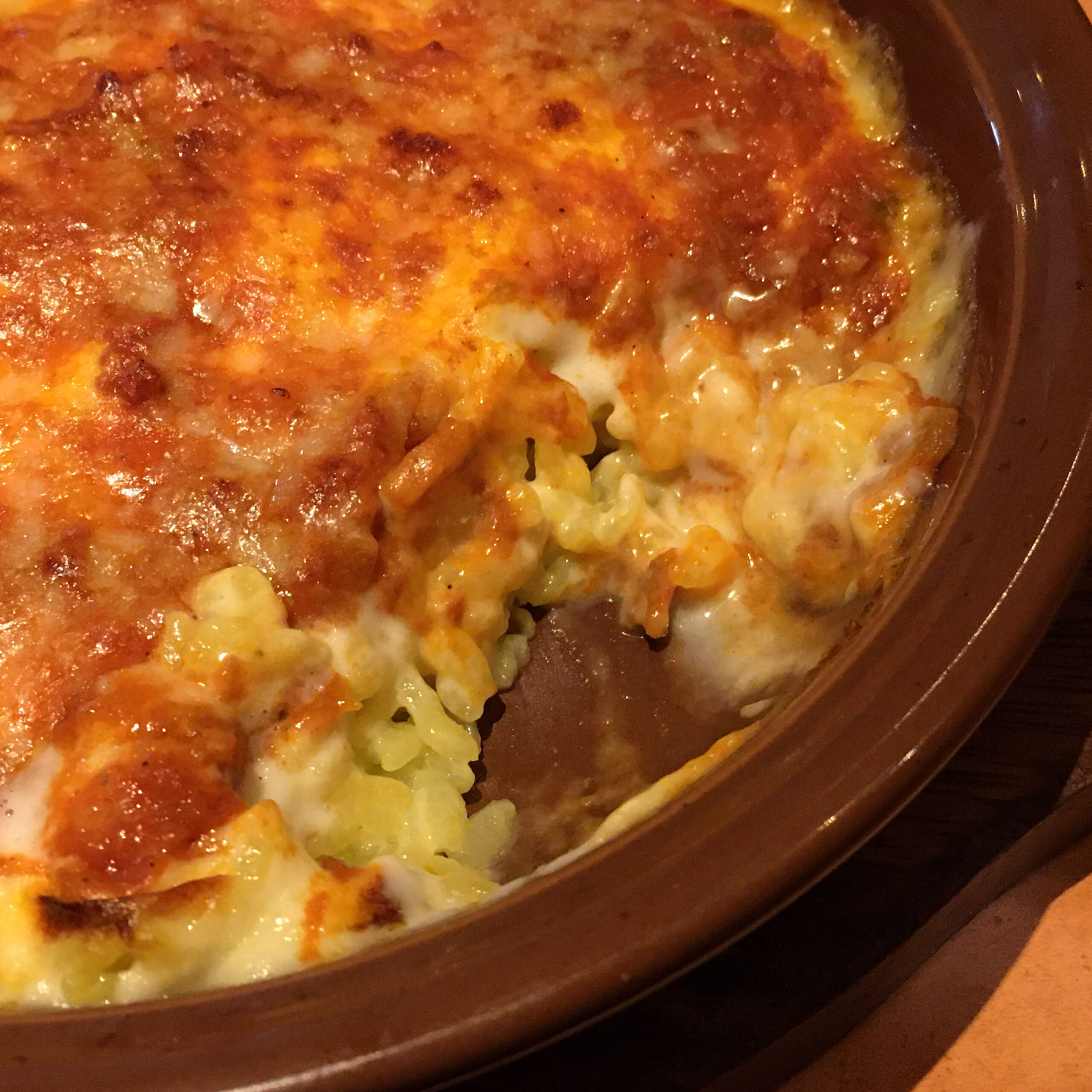 Saizeriya's Milan-style doria, a baked rice dish with browned cheese on top and the middle scooped out