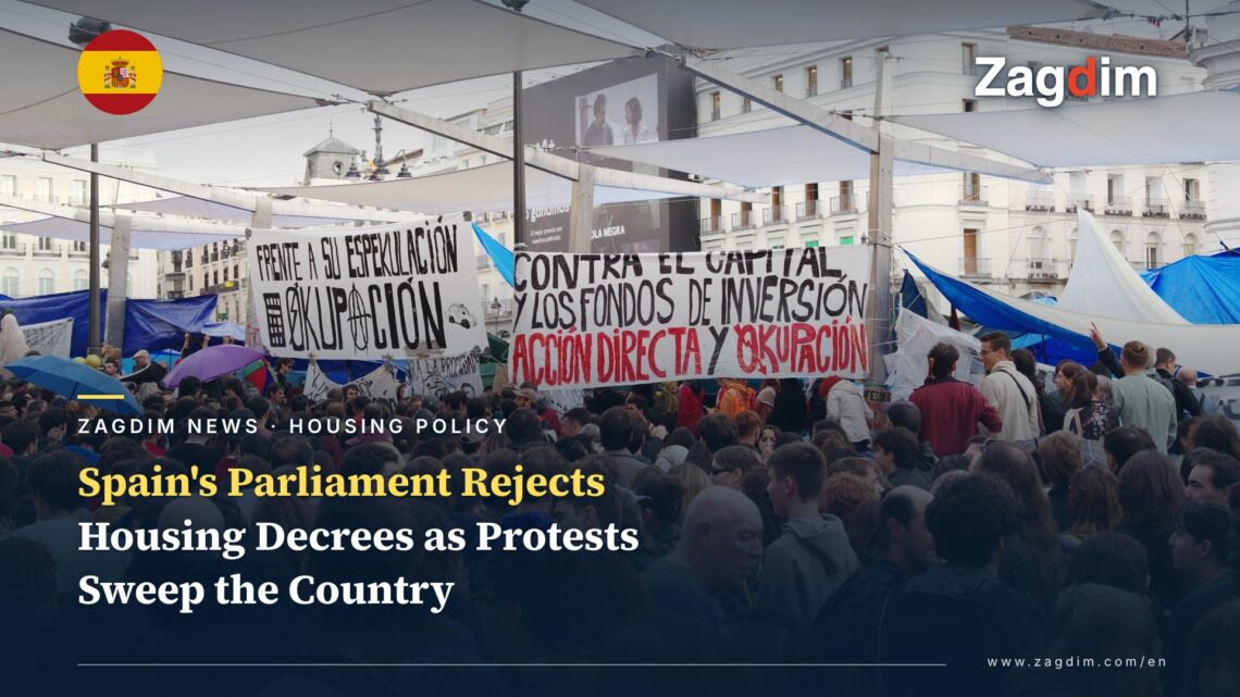 Crowd at the Puerta del Sol housing-protest encampment in Madrid holding hand-painted banners opposing investment funds