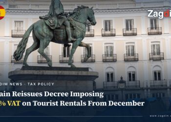Equestrian statue of Carlos III in Madrid Puerta del Sol, its base spray-painted TOURIST GO HOME, with a housing-protest tent camp behind it
