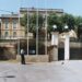 A formal consulate building with gates, flagpoles, and a uniformed guard