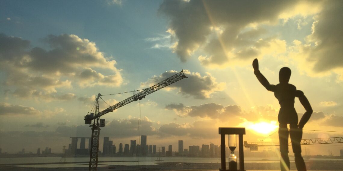 Abu Dhabi skyline at sunset seen past a construction crane