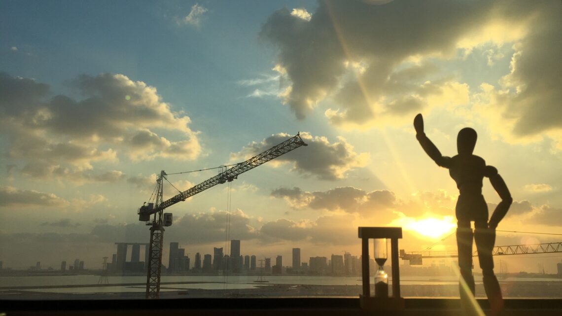 Abu Dhabi skyline at sunset seen past a construction crane