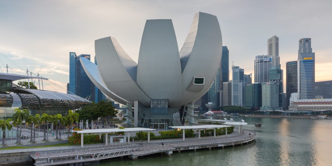 ArtScience Museum, Marina Bay Sands, in the late afternoon, in front of the skyline of the Central Business District, Singapore. Architect : Moshe Safdie.