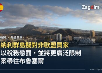 特內里費島洛斯克里斯蒂亞諾斯海岸的公寓大樓與白色住宅,後方為山脈,前方海面平靜、停泊一艘帆船