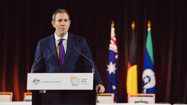Australian Treasurer Jim Chalmers speaking at a lectern with Australian Government signage