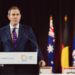 Australian Treasurer Jim Chalmers speaking at a lectern with Australian Government signage
