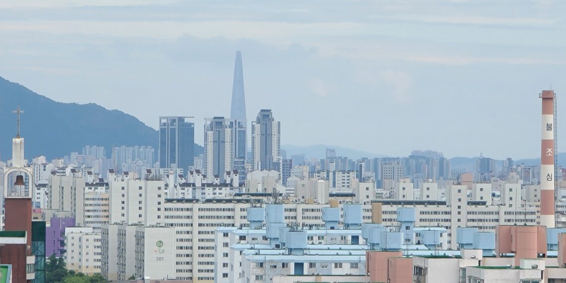 首爾蘆原區成排公寓大樓,背景天際線可見樂天世界塔——蘆原區是報導中2030年恐首次被納入綜合不動產稅課稅範圍的三區之一