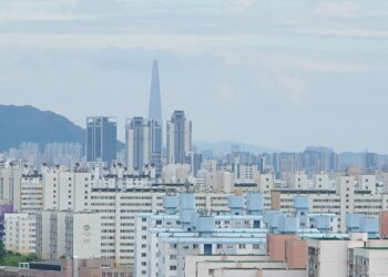 首爾蘆原區成排公寓大樓,背景天際線可見樂天世界塔——蘆原區是報導中2030年恐首次被納入綜合不動產稅課稅範圍的三區之一