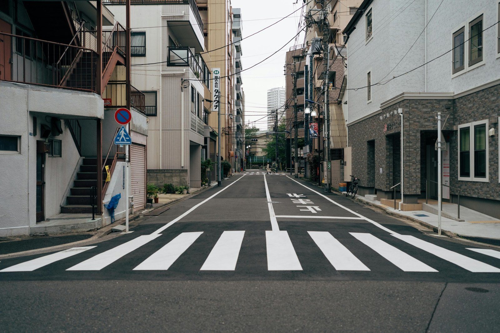 東京住宅街道上的斑馬線,兩側是中低層公寓與住商大樓