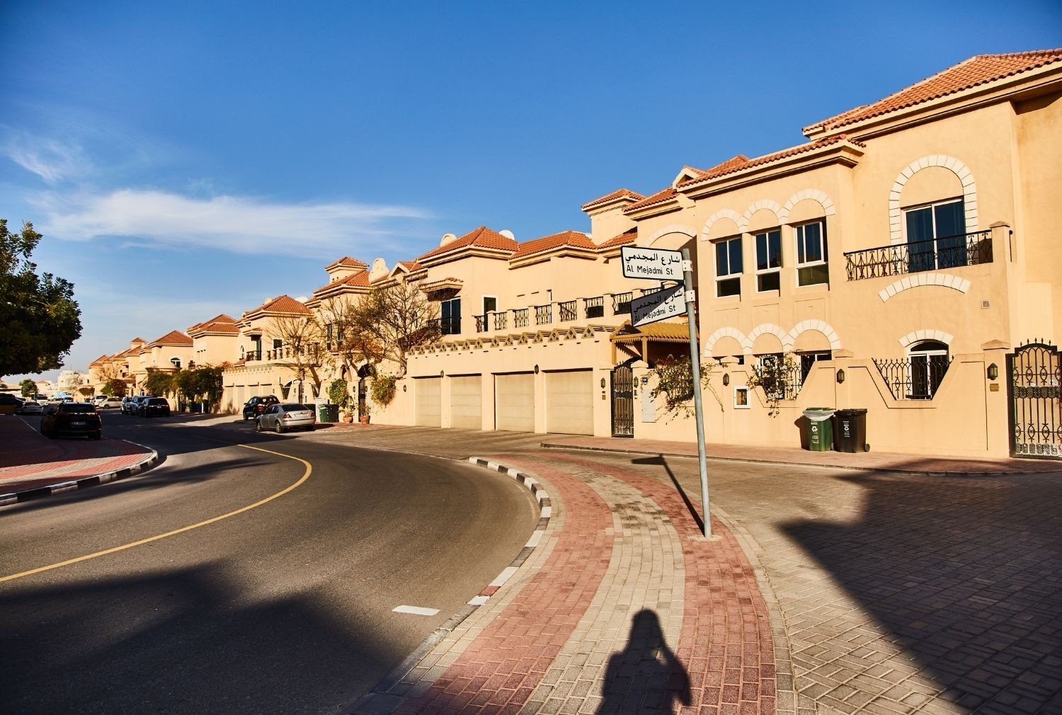 杜拜住宅區一排砂岩色的連棟別墅,街角有 Al Mejadmi St 路牌