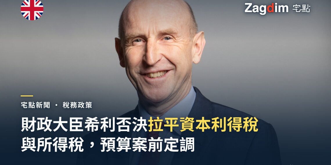 英國財政大臣約翰·希利（John Healey）官方議員肖像，灰背景正面微笑照，配文報導他否決把資本利得稅拉平至所得稅水平