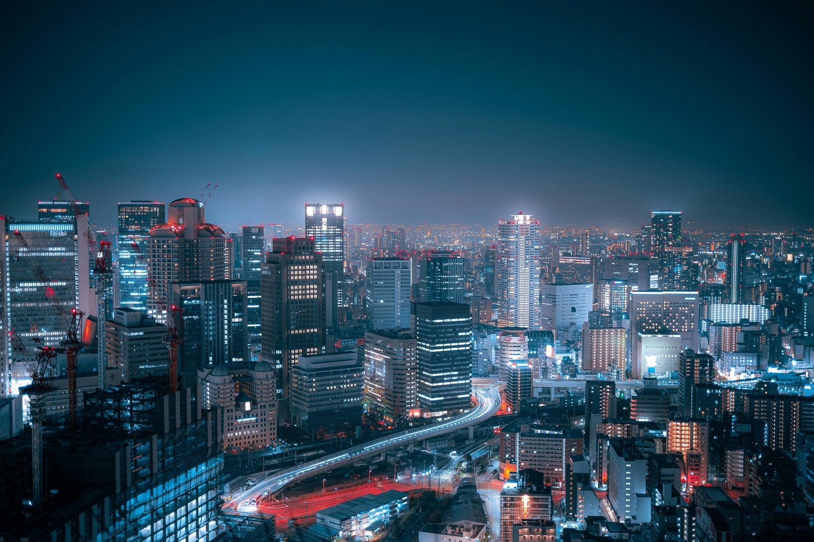 從高處俯瞰的日本城市夜景,密集的高樓與住宅亮著燈