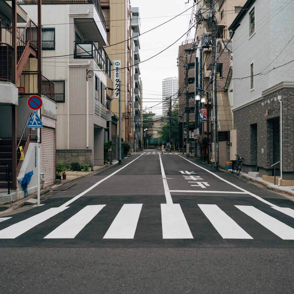日本住宅街道兩旁的公寓與行人穿越線,海外業主出租、出售及房產稅務情境