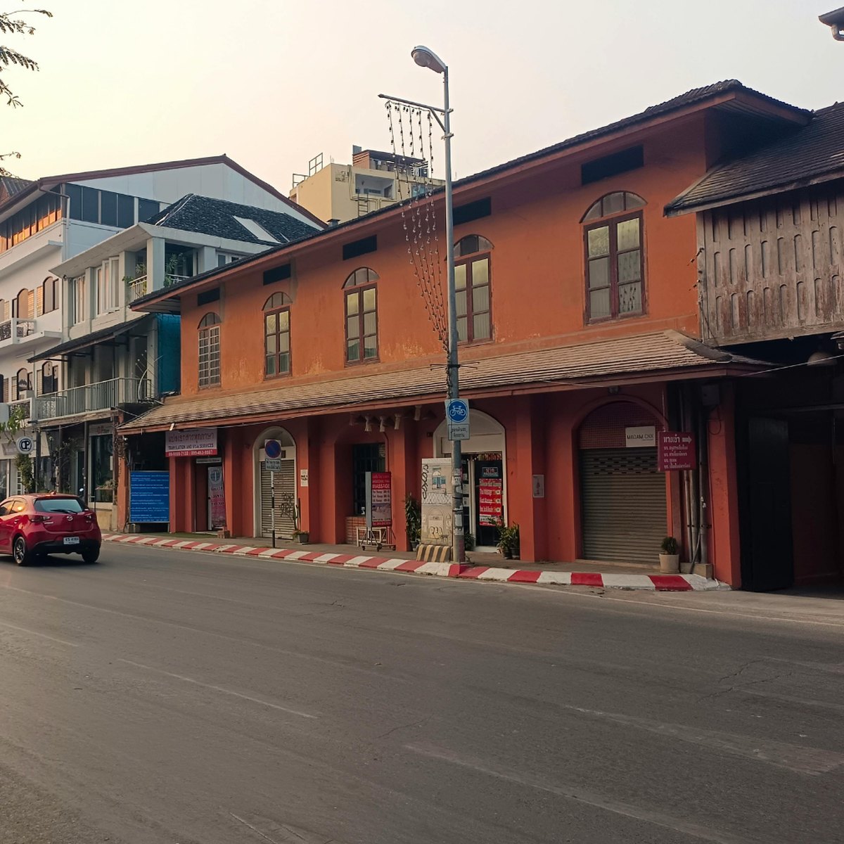 曼谷街邊的老式店屋與騎機車的人,配在泰國經營小型事業主題