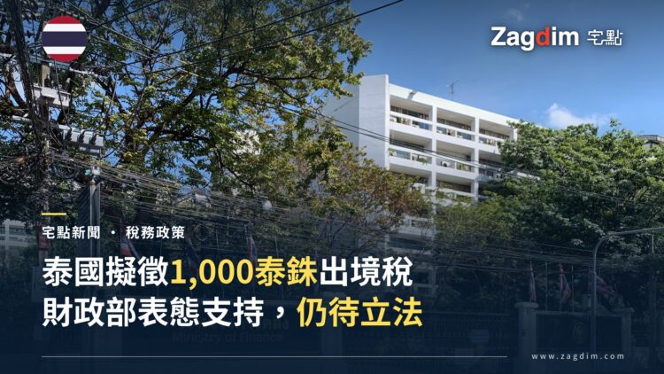 泰國財政部位於曼谷的辦公大樓正門招牌(中英文「กระทรวงการคลัง/Ministry of Finance」),圍牆外可見泰國國旗,配合泰國出境稅提案新聞