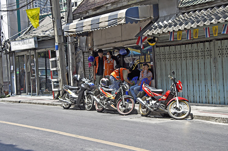 曼谷街頭的摩托計程車站點,司機穿橘色背心