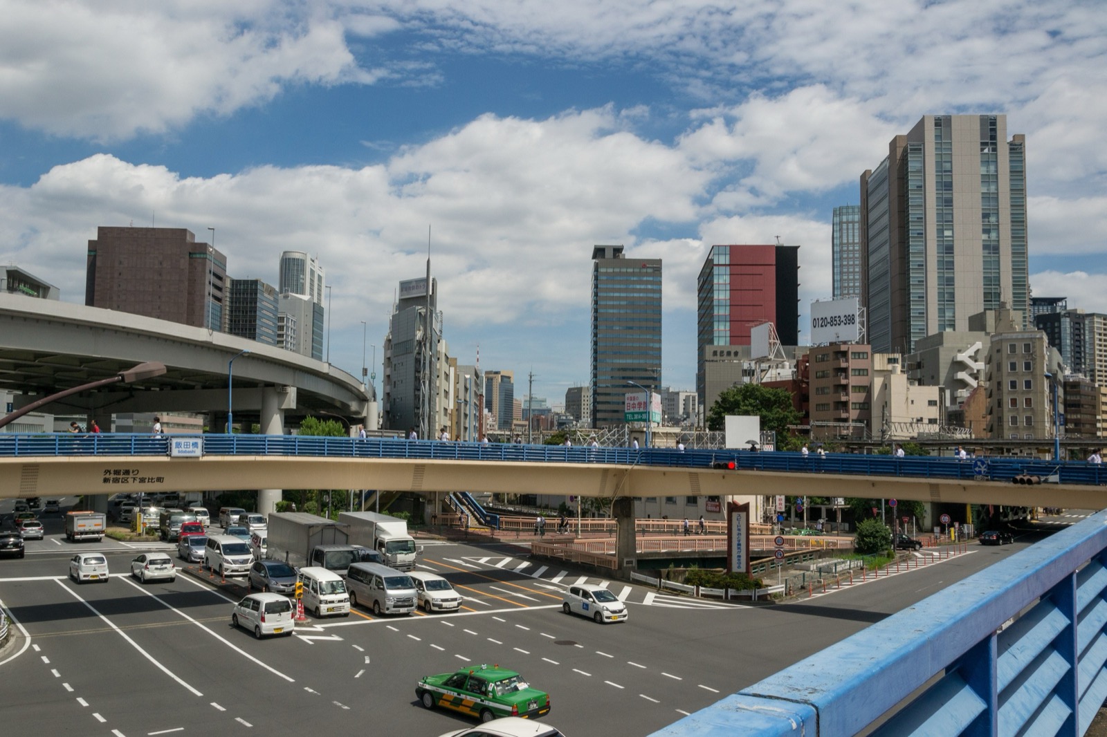 東京飯田橋一帶的高架道路與大型路口,車流與遠方的辦公大樓